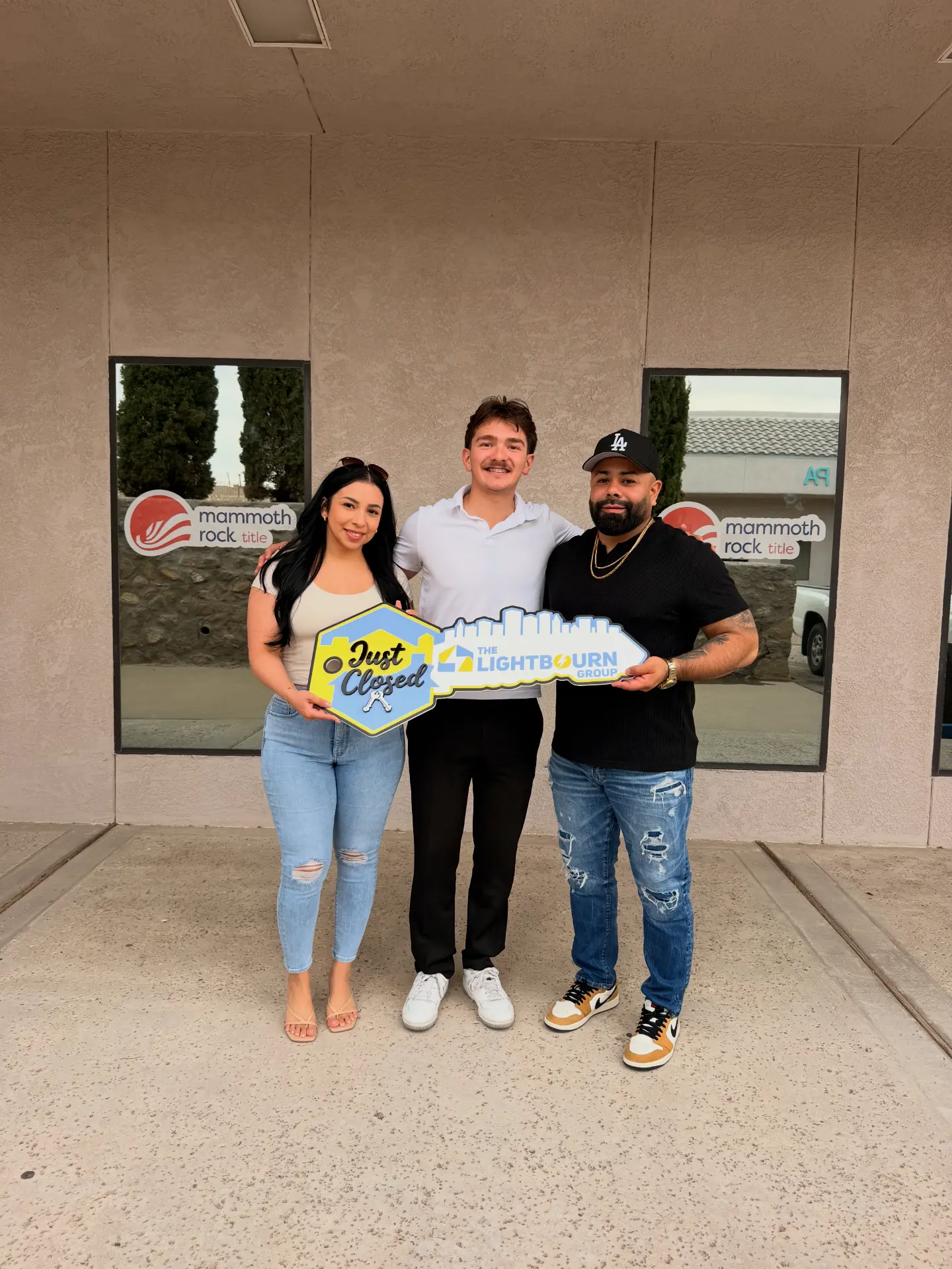 Our team with Jesus and Bianca outside the title company holding Just Closed signage
